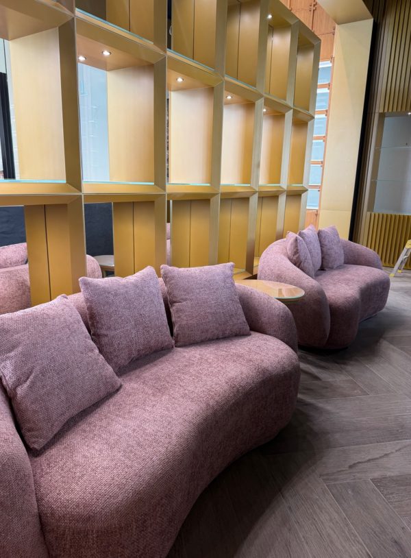 Curved lounge seating and timber shelving in the Ajmal boutique at Westfield London