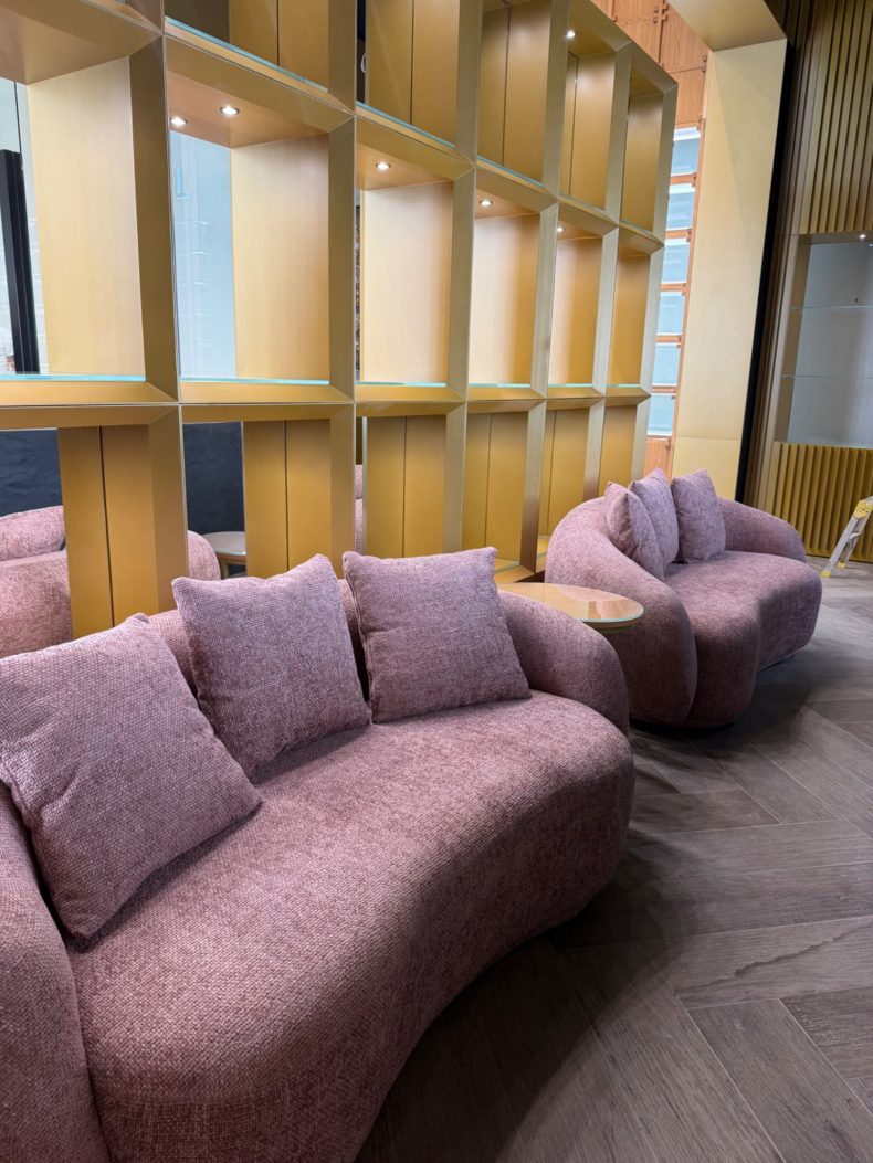 Curved lounge seating and timber shelving in the Ajmal boutique at Westfield London