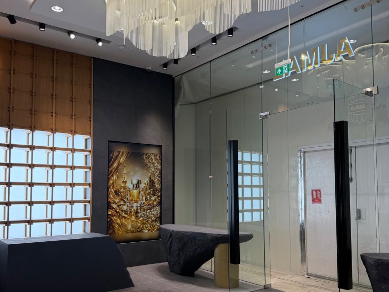 Boutique interior with a sculptural ceiling feature and glass partition in the Ajmal Perfumes store at Westfield London
