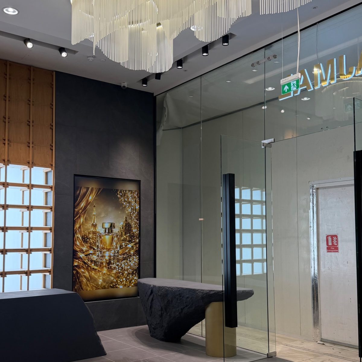 Boutique interior with a sculptural ceiling feature and glass partition in the Ajmal Perfumes store at Westfield London