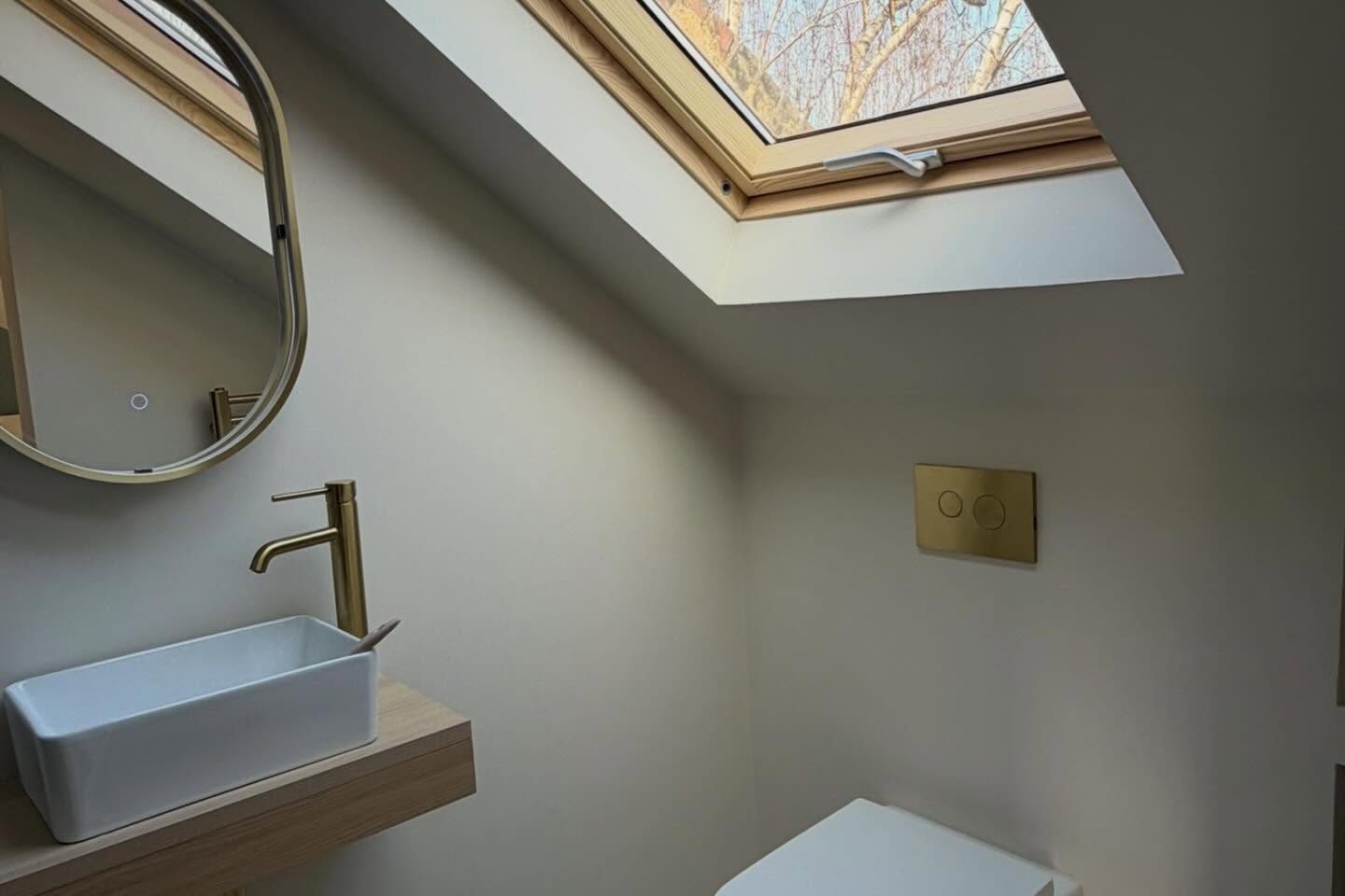 Loft en-suite under a rooflight by BRX London