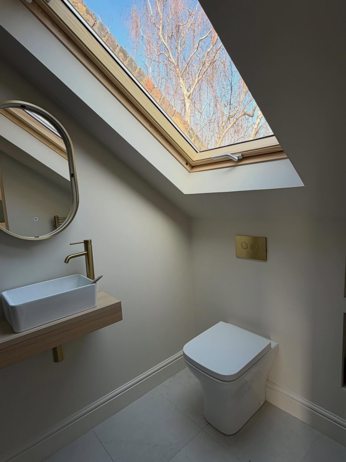 Loft en-suite under a rooflight by BRX London